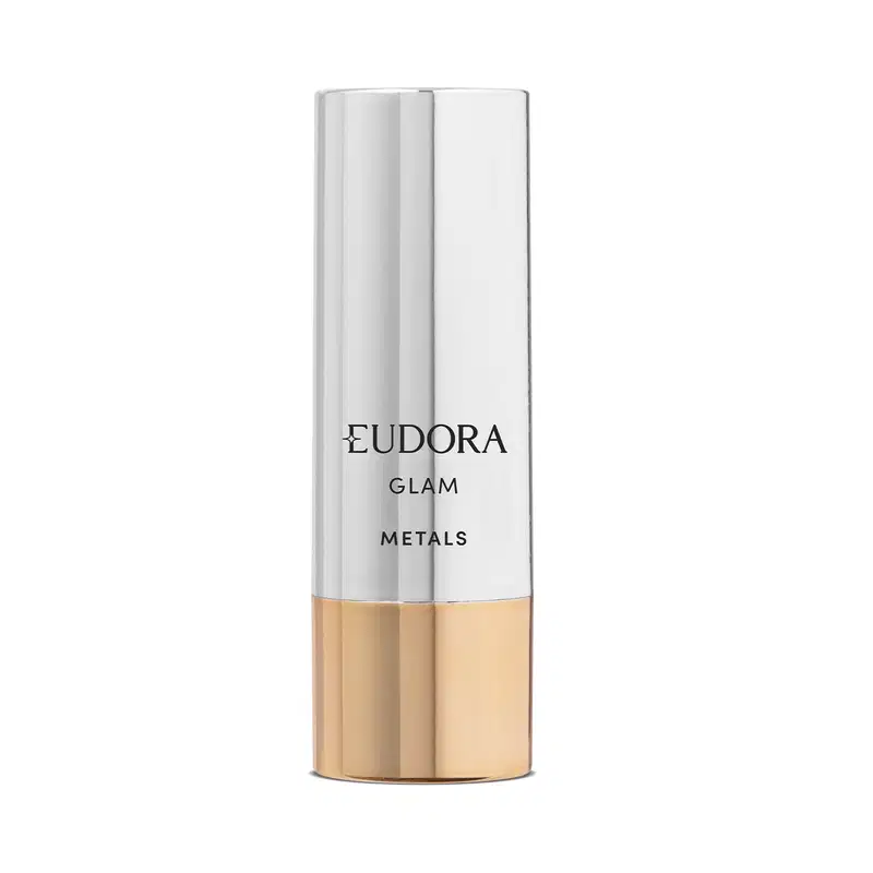 Produto fechado, onde é possível ver a base dourada e toda a parte superior prateada. Rótulo preto com o nome da marca "Eudora" e a linha "Glam Metals" em letras maiúsculas. Design minimalista e elegante.