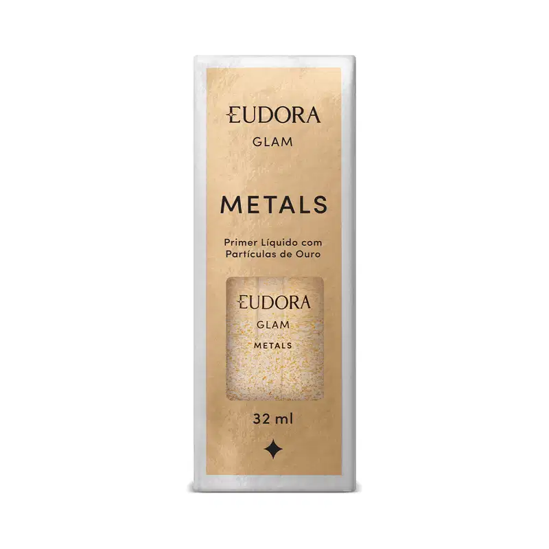 Embalagem retangular de papelão kraft com detalhes impressos em preto. Frasco de vidro transparente com o produto dourado visível através da embalagem. Rótulo com o nome Eudora Glam Metals e informações como Primer Líquido com Partículas de Ouro e 32ml.
