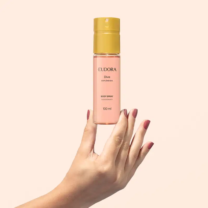 Produto de beleza da marca Diva, em embalagem rosa e dourada, com mãos femininas segurando o frasco, em ambiente claro e neutro.