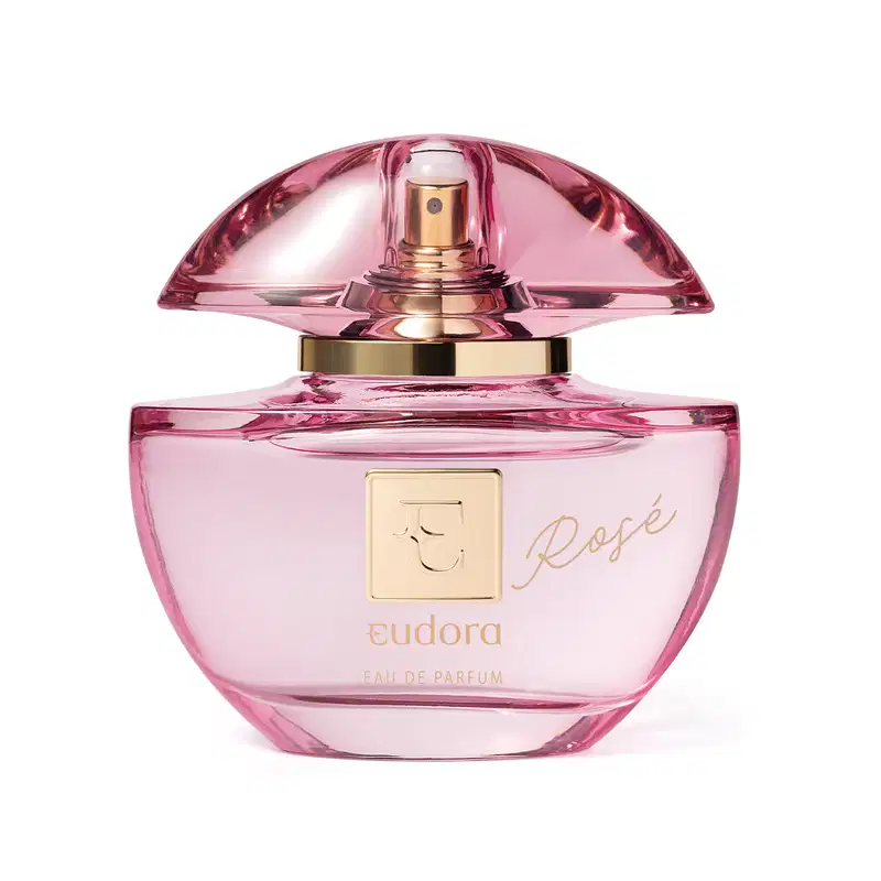 Frasco do Eau de Parfum Eudora Rosé. O frasco é feito de vidro rosa com detalhes em dourado. Na parte frontal, está gravado o nome "Rosé" em letras douradas cursivas. O topo do frasco tem uma tampa em vidro que deixa entrever a parte dourada do borrifador
