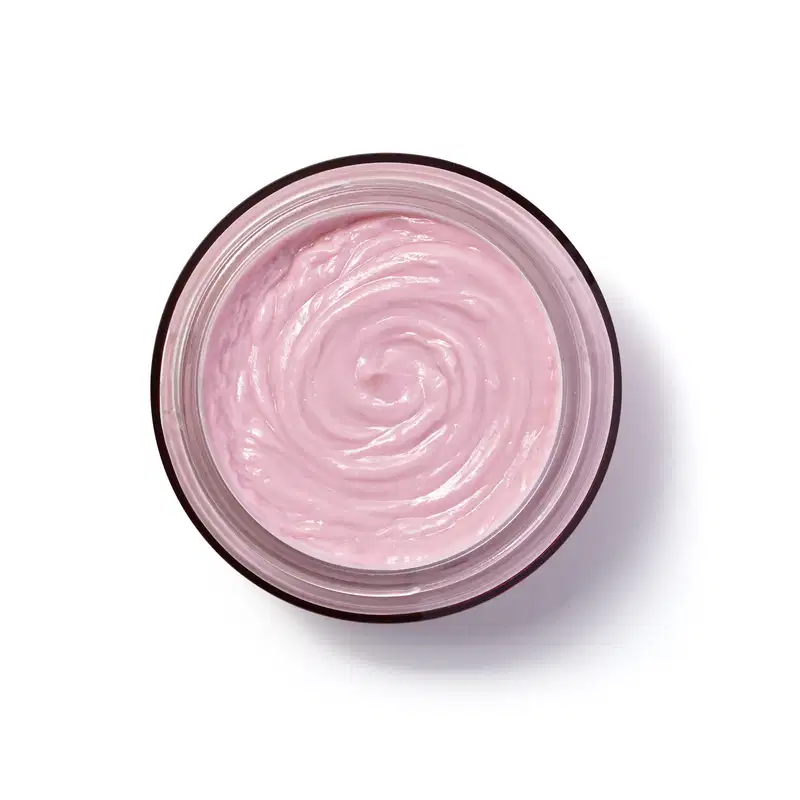 A imagem mostra a embalagem de vidro do hidratante Eudora Rosé vista de cima. O produto tem uma textura cremosa e espiral bem definida na cor rosada. Visto de cima, a embalagem é circular.
