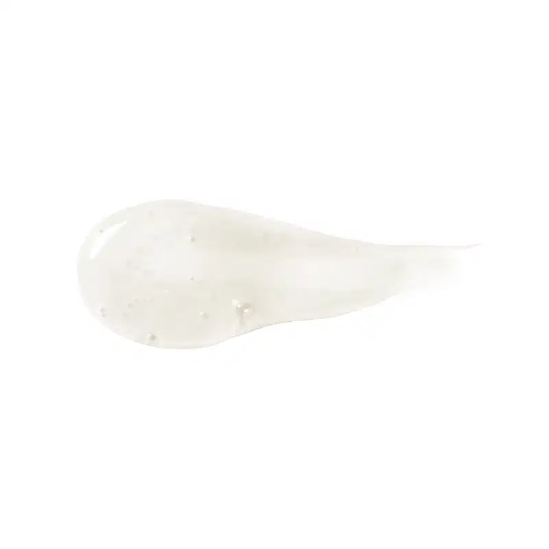 Textura do produto Shampoo de Siàge. Possui um formato alongado e irregular, com uma superfície esbranquiçada e com algumas manchas ou pontos visíveis. Não há rótulos, textos ou outras informações visíveis na embalagem.