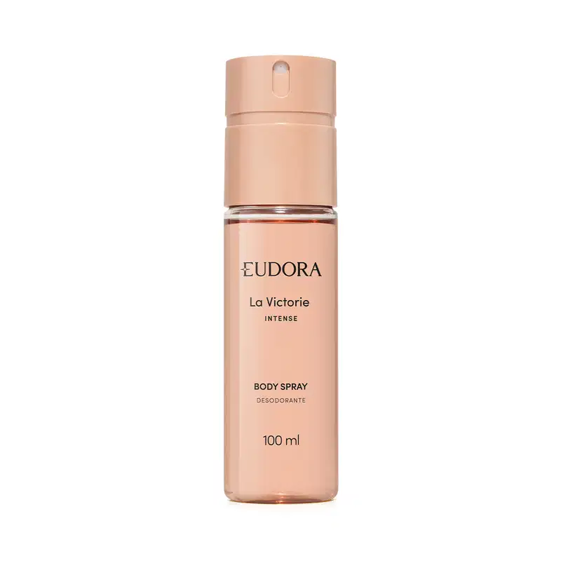 Embalagem cilíndrica de plástico rígido na cor nude rosado. Rótulo com o nome do produto "La Victorie Intense Body Spray Desodorante" e a informação de volume de 100ml. Tampa tipo spray na parte superior. Design minimalista e elegante.