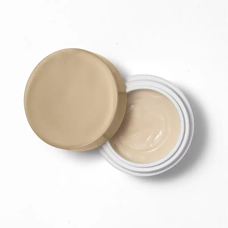 Imagem vista de cima do produto Creme de Contorno Facial, com a tampa aberta, sendo possível ver a parte interna do recipiente, que indica uma textura cremosa e lisa.