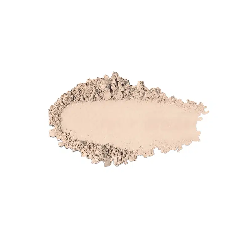 Textura de pó compacto com acabamento aveludado e superfície irregular, em quantidade moderada sobre fundo branco.