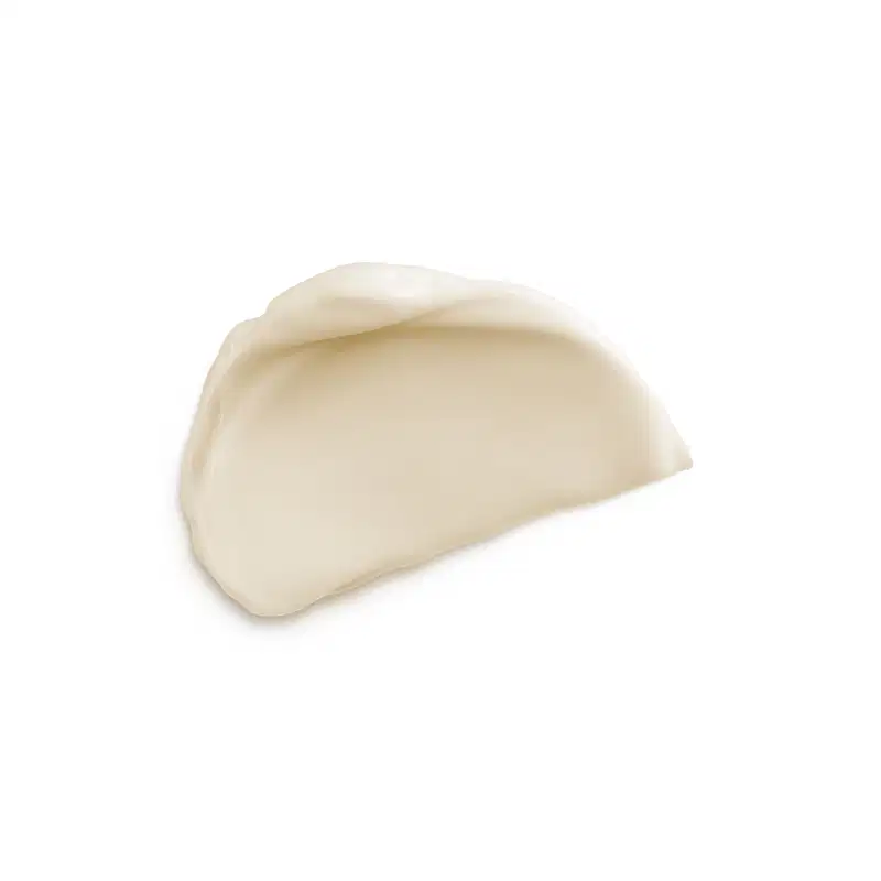 A imagem apresenta amostra do creme com textura cremosa de cor bege claro.