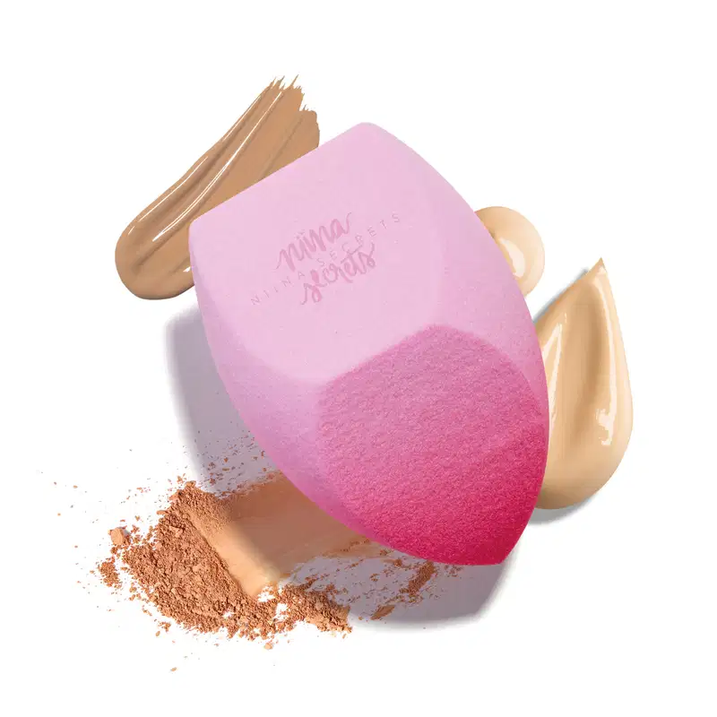Esponja Pink Blend Niina Secrets com um fundo em diferentes texturas cremosas e em pó.