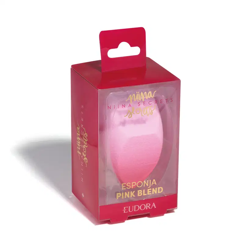 Esponja Pink Blend dentro da embalagem, que é transparente na frente, sendo possível ver o produto, mas rosa nos demais lados. Escritos em dourado.