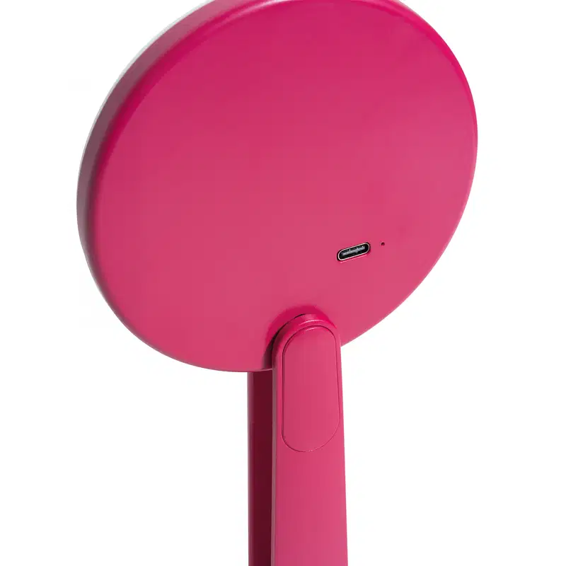 O produto apresentado é a parte de trás do espelho led da marca Niina Secrets, todo em rosa. Possui um design circular com uma entrada USB-C visível na parte inferior, indicando que pode ser carregado ou conectado a uma fonte.