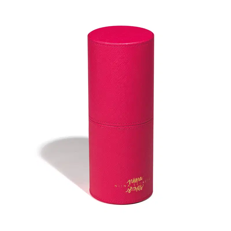 Embalagem cilíndrica de cor rosa vibrante, com textura aveludada e rótulo com a marca "Nina Secrets" em dourado. Trata-se do Estojo Organizador para Pincéis Pink Case.