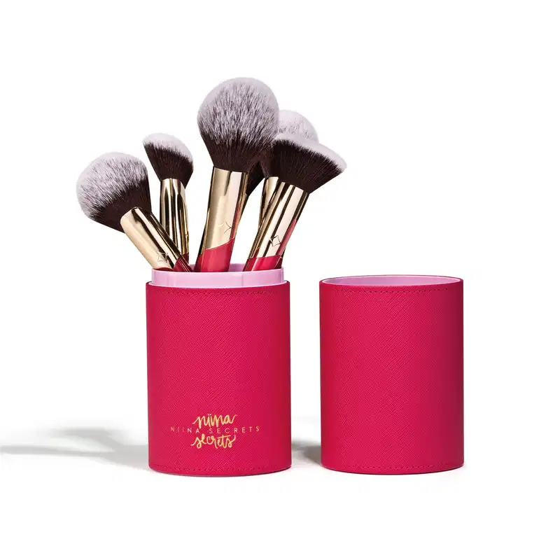 Conjunto de pincéis de maquiagem da marca Niina Secrets em embalagem cilíndrica rosa Estojo Organizador para Pincéis Pink Case Niina Secrets, contendo diversos pincéis com cerdas pretas e douradas.