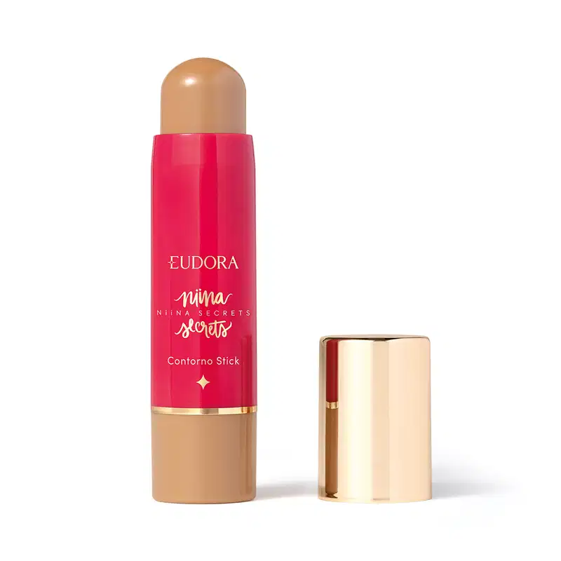 O produto apresentado é um contorno em bastão da linha Niina Secrets. A embalagem é cilíndrica e de cor rosa vibrante, com o nome da marca e da linha impressos em letras douradas. A embalagem também possui um detalhe dourado na parte superior.