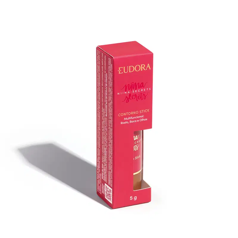 A embalagem do Contorno Stick é uma caixa rosa com o nome da marca e da linha impressos em dourado. O produto em si é um bastão de maquiagem com uma tampa protetora.