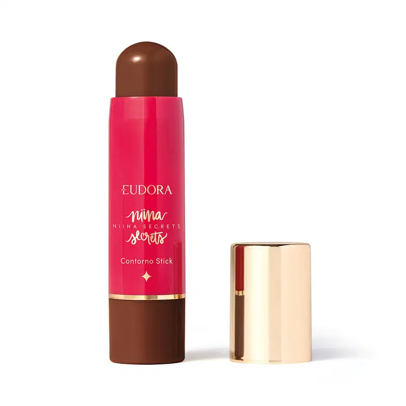 O produto apresentado é um contorno em bastão da linha Niina Secrets. A embalagem é cilíndrica e de cor rosa vibrante, com o nome da marca e da linha impressos em letras douradas. A embalagem também possui um detalhe dourado na parte superior.