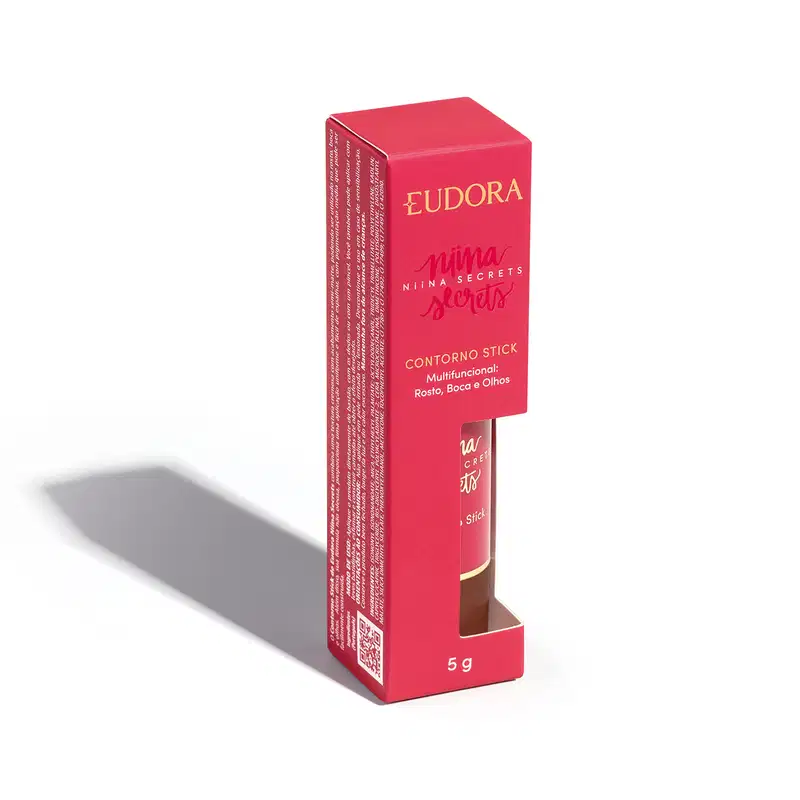 A embalagem do Contorno Stick é uma caixa rosa com o nome da marca e da linha impressos em dourado. O produto em si é um bastão de maquiagem com uma tampa protetora.
