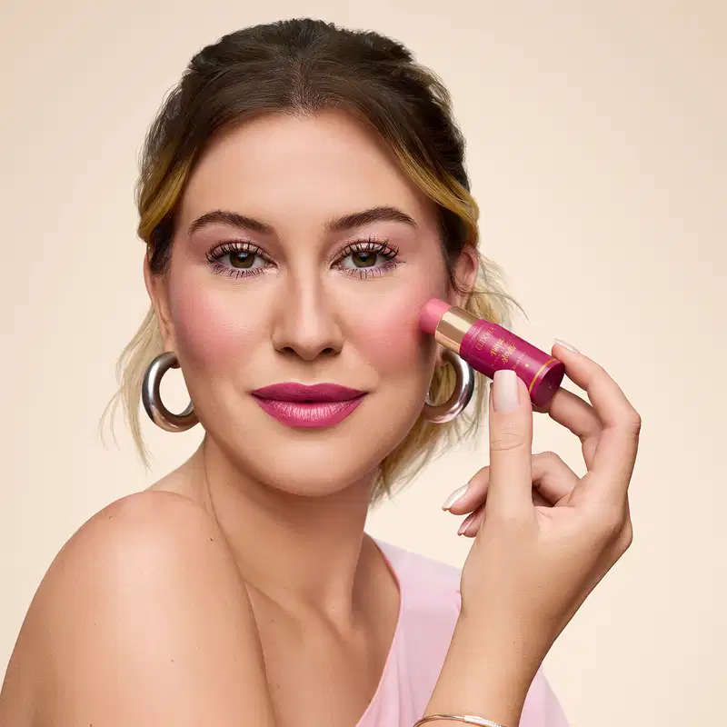 Imagem da Niina aplicando o Blush Stick na região da bochecha.