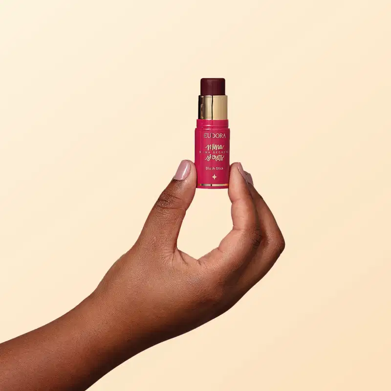 Mão feminina segurando o produto Blush Stick Daily Amora de Niina Secrets.