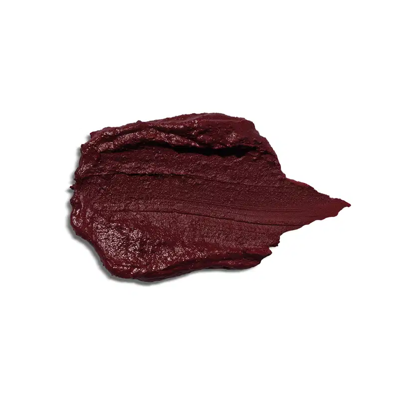 Textura do Blush Stick, com uma consistência cremosa e pigmentação intensa. De cor vinho escuro. Na imagem não mostra nenhuma embalagem ou outras informações.