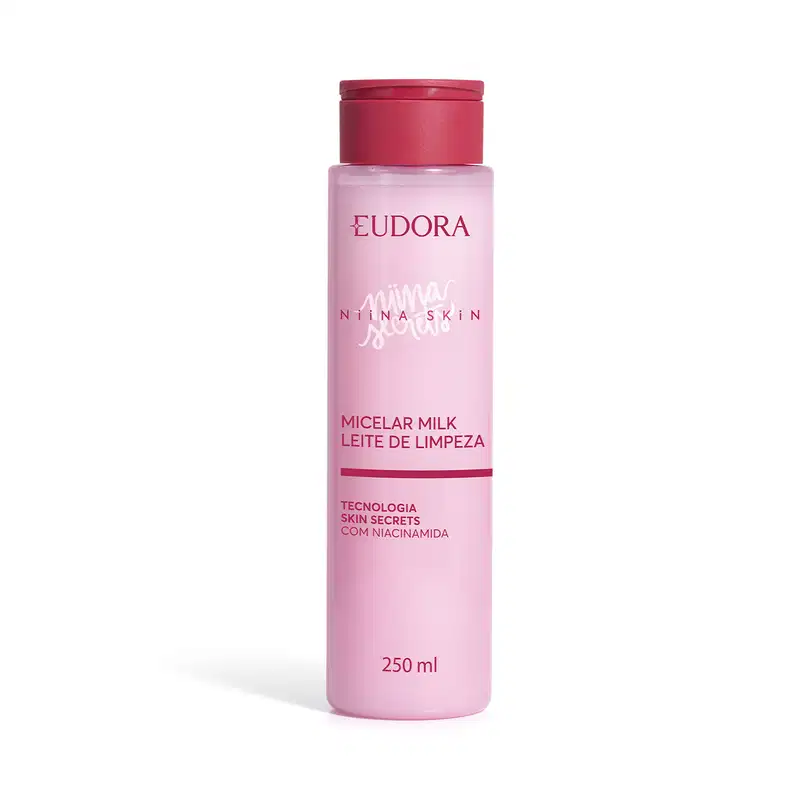 Frasco de leite micelar rosa da marca Eudora Niina Skin, com tampa pink, contendo 250 ml, com texto "Micelar Milk Leite de Limpeza" e "Tecnologia Skin Secrets com Niacinamida" visível no rótulo.