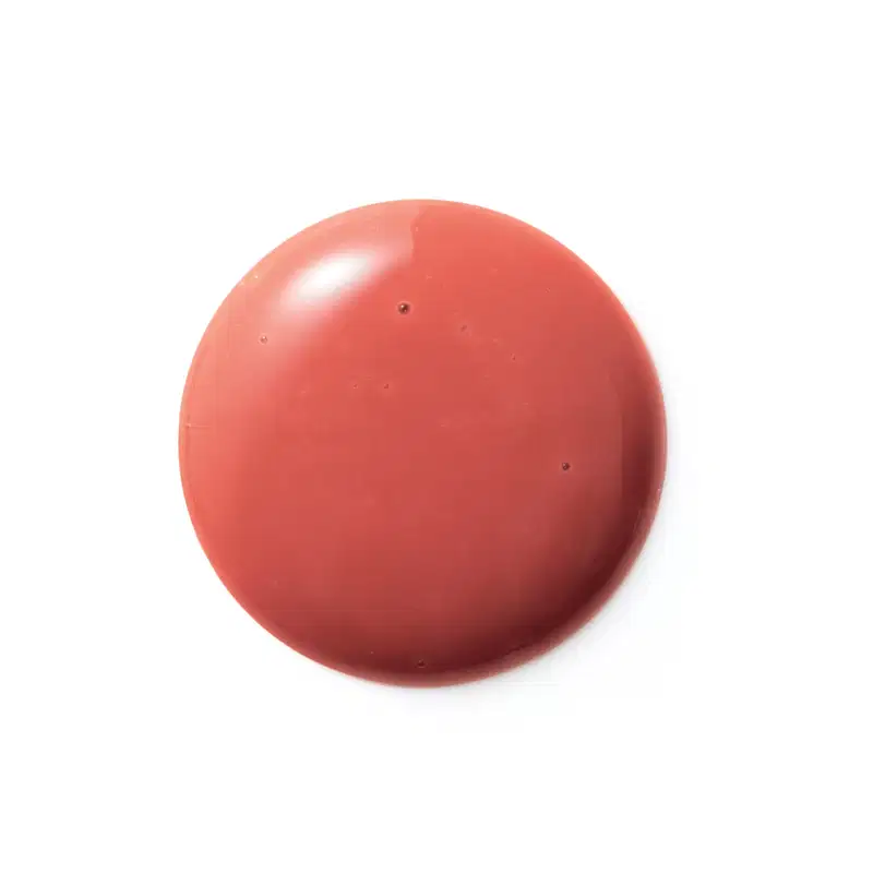 Textura cremosa e brilhante, com tonalidade coral uniforme. Aparência suave e homogênea, sem imperfeições visíveis. Produto de beleza com acabamento aveludado e aspecto saudável.
