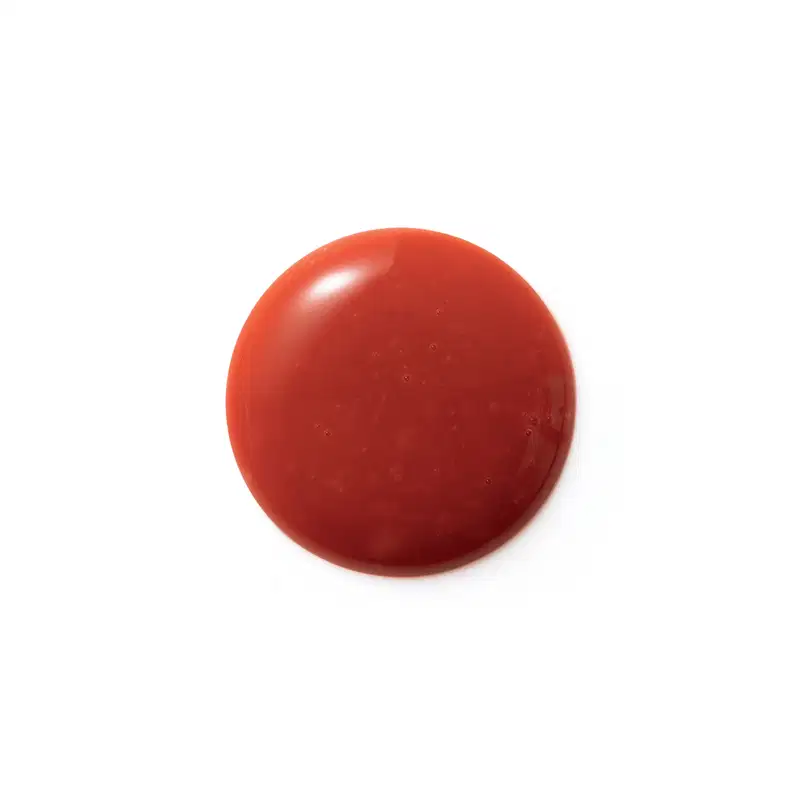 Textura cremosa, brilhante e uniforme em tom vermelho intenso, com aparência lisa e suave ao toque, típica de um produto de beleza da linha Eudora Make.