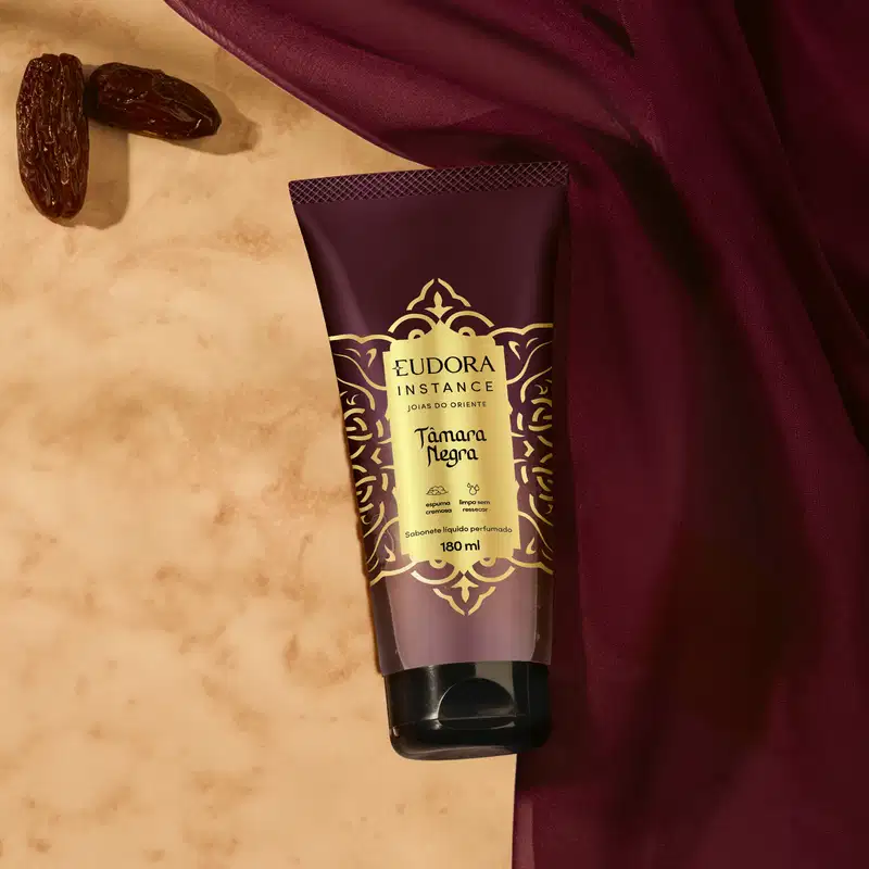 Sabonete líquido perfumado Eudora Instance Tâmara Negra em embalagem tube de 180ml. Frasco com predominância de cores marrom e dourado, decorado com padrões ornamentais. Rótulo destaca "espuma cremosa" e "limpa sem ressecar".