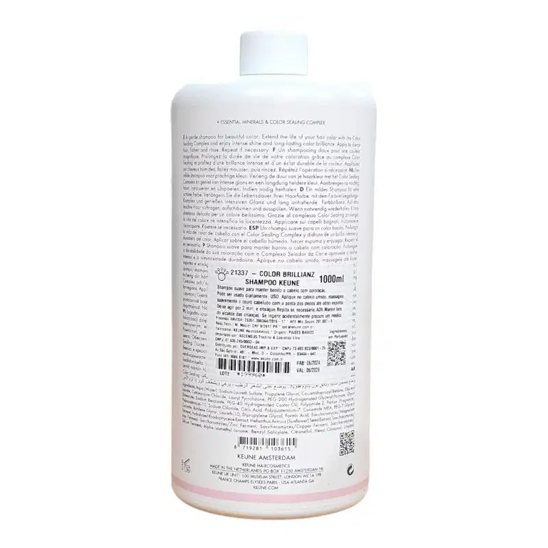 O produto é um frasco de shampoo da marca Keune, com 1000ml de volume, com rótulo branco e detalhes em rosa. O rótulo contém informações sobre o produto, incluindo o nome "Color Brillianz Shampoo".