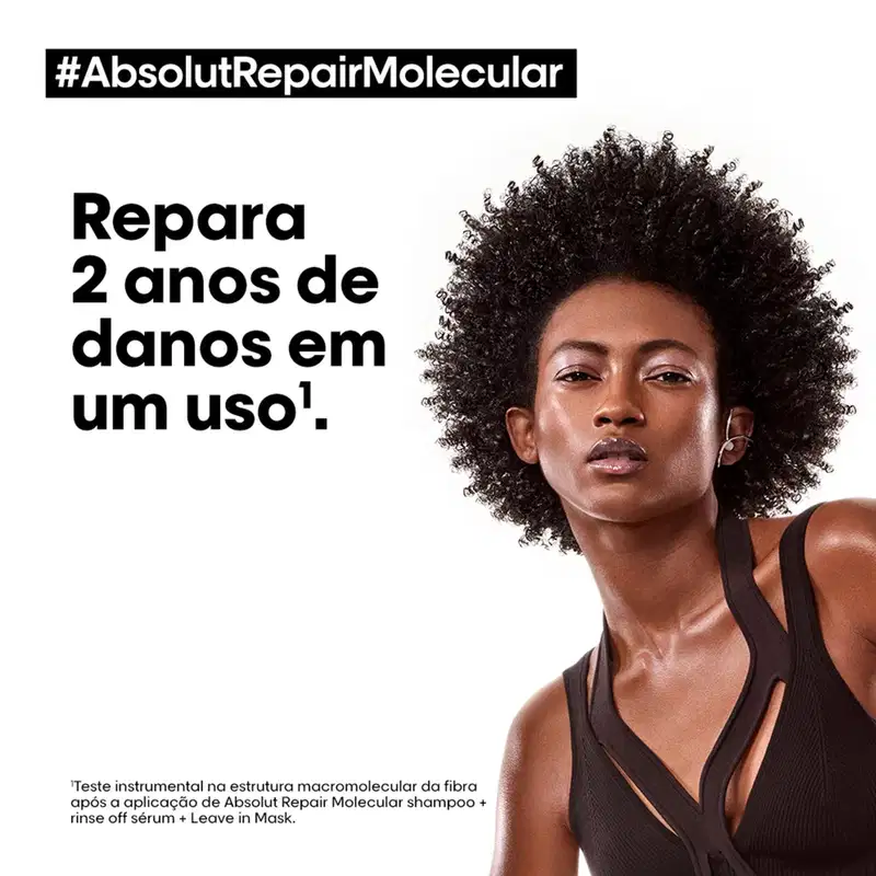 A imagem apresenta uma mulher afro-brasileira com cabelos crespos e volumosos, em um ambiente de divulgação de um produto de tratamento capilar da marca L'Oréal Professionnel, com destaque para o texto "#AbsolutRepairMolecular".
