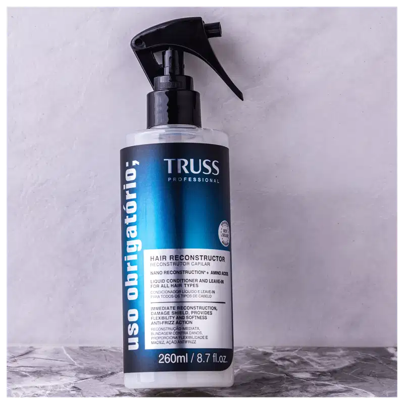 Produto de reconstrução capilar TRUSS Professional. Embalagem em frasco plástico transparente com aplicador spray preto. Rótulo azul e branco com o nome do produto "Hair Reconstructor".