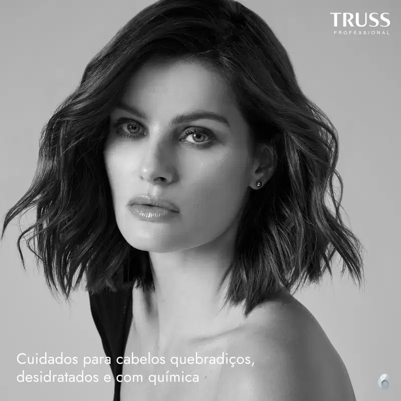 A imagem mostra uma mulher com cabelos escuros e ondulados até os ombros, em um close-up em preto e branco. O texto na parte inferior indica que se trata de cuidados para cabelos quebradiços, desidratados e com química.
