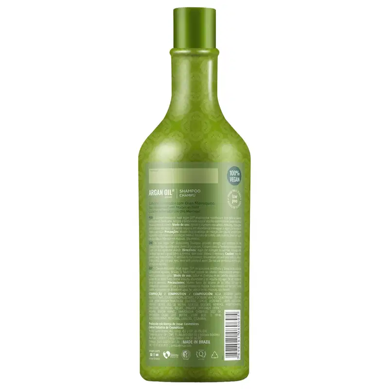 Shampoo de óleo de argan da marca Inoar. Embalagem em frasco plástico verde translúcido com formato cilíndrico alongado e tampa verde. Rótulo frontal com informações do produto como "Argan Oil Shampoo", "100% Vegan" e composição.