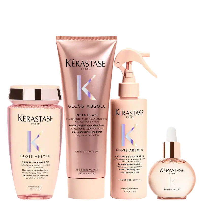 Produtos Kérastase em embalagens rosa e bege, incluindo shampoo, condicionador, spray e sérum para cabelos. As embalagens apresentam o logotipo da marca e informações sobre os benefícios dos produtos, como redução do frizz e brilho.
