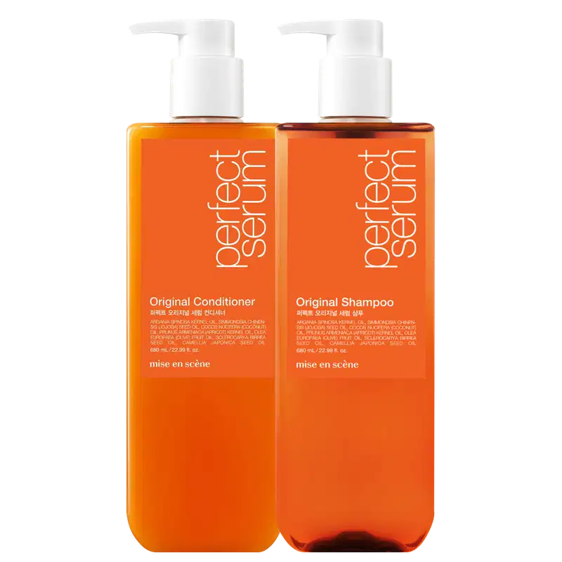 Dois frascos de plástico laranja com bombas brancas, contendo Shampoo Original e Condicionador Original da marca Mise en Scène. Os rótulos exibem informações sobre os ingredientes e a marca.