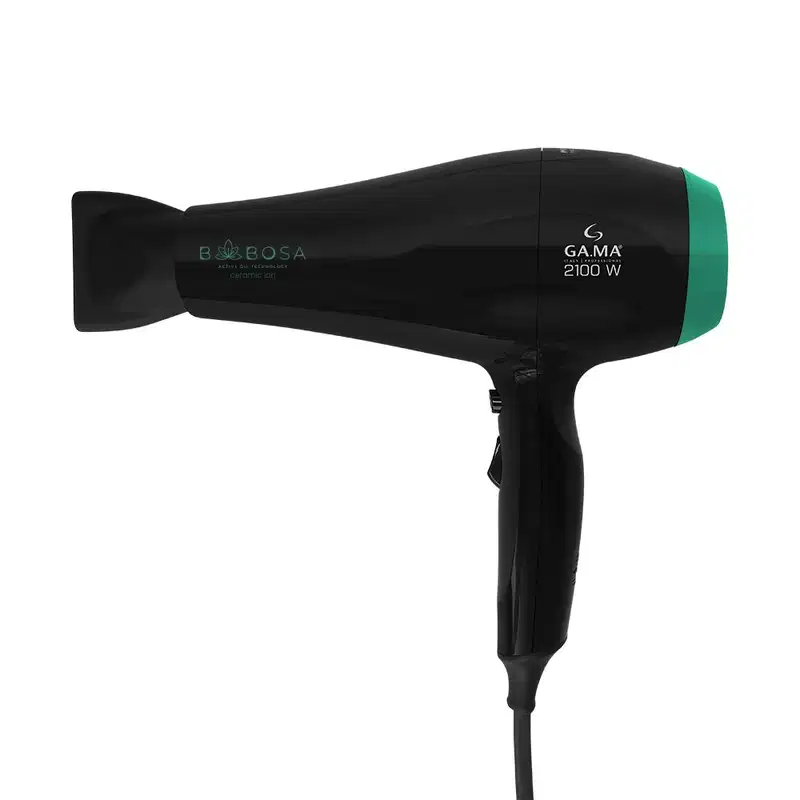 A imagem mostra o secador de cabelo GA.MA Italy. Ele possui o corpo preto com detalhes em verde. Possui o logotipo "GA.MA" e a potência "2100 W" impressos na lateral. Design ergonômico com alça de pegada confortável.