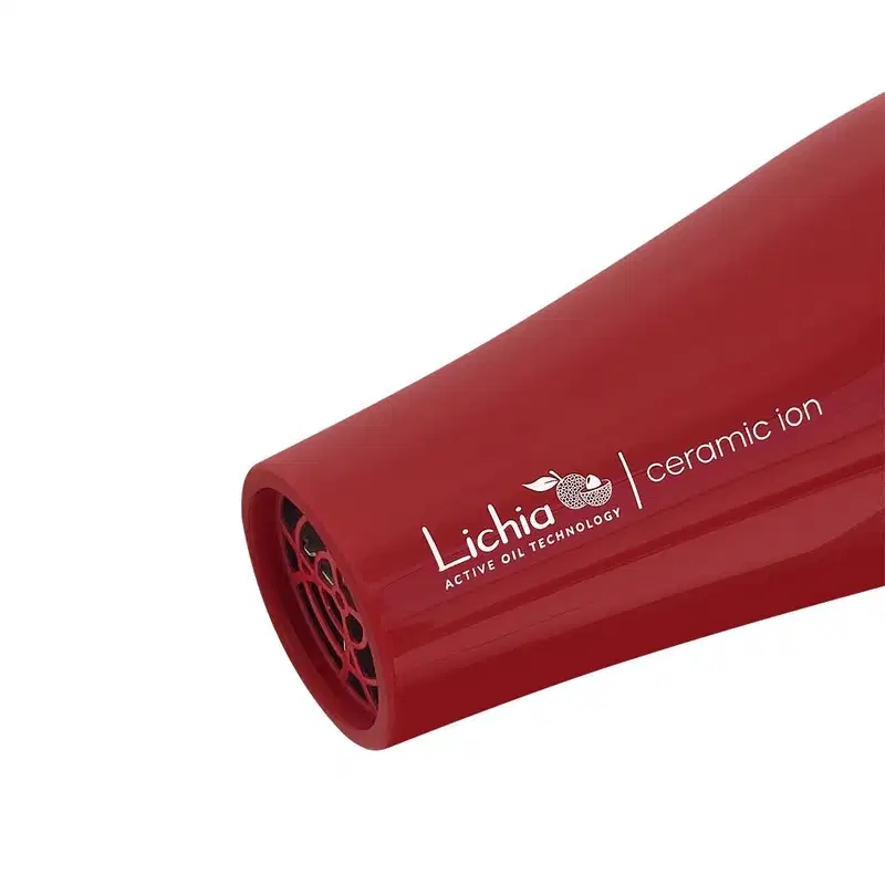 A imagem mostra a ponta do secador. O corpo é cilíndrico, vermelho e traz uma grade vazada na saída de ar. Na lateral possui o logotipo e nome da marca "Lichia Ceramic Active Oil Technology" impresso em letras brancas.
