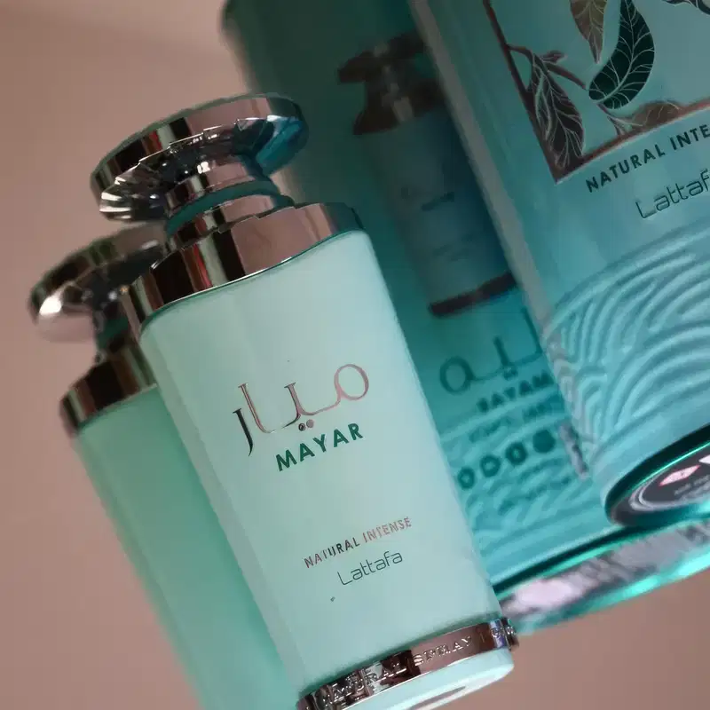 Recipiente de item de perfumaria com design minimalista em tons de verde e branco. O produto está posicionado em um ambiente com folhagens, sugerindo um contexto natural e de cuidados com a pele.