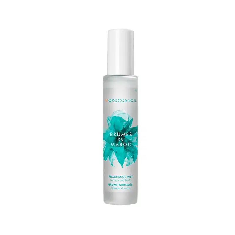 A imagem mostra o produto Moroccanoil Brumes du Maroc 100ml.  O rótulo indica que é um "Fragrance Mist" (Bruma Perfumada). O design do rótulo apresenta folhas estilizadas de tom turquesa sobre um fundo branco, dando uma aparência inspirada na natureza.