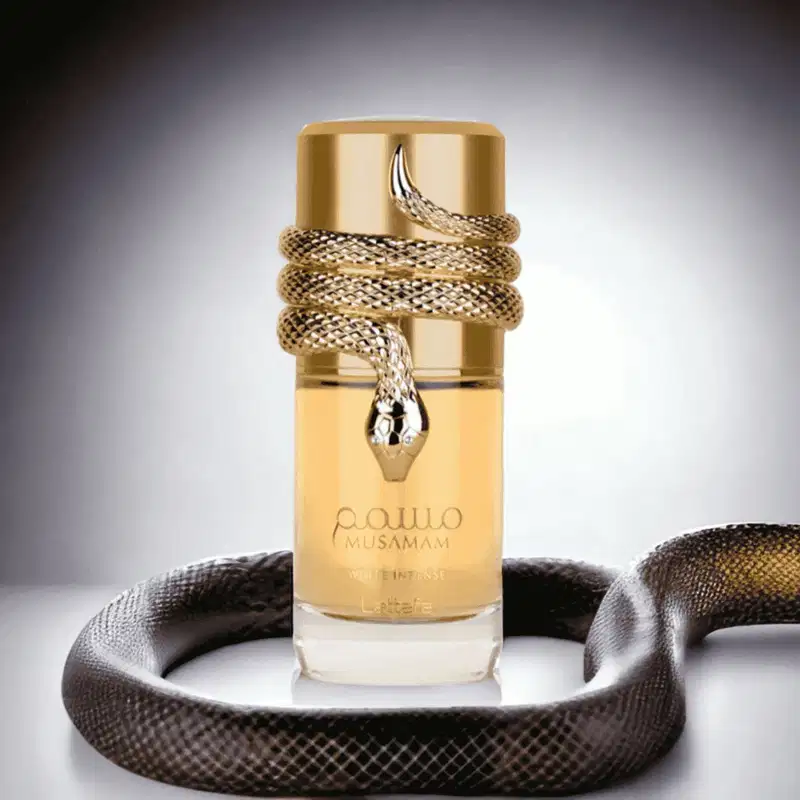 Recipiente de item de perfumaria dourado com cobra enrolada em volta, em ambiente escuro com tecido de textura próximo. Produto da marca Musamam em destaque.