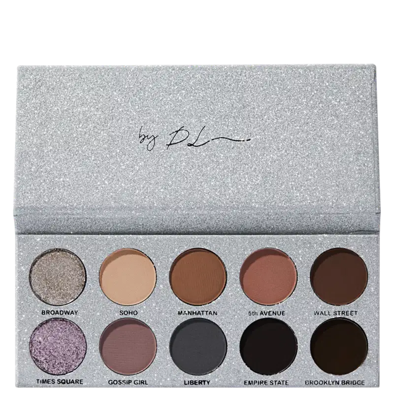 Paleta de sombras de olhos compacta com embalagem retangular de aparência glitter prateada. A caixa contém 10 sombras prensadas em tons neutros e profundos, variando do bege claro ao marrom escuro.