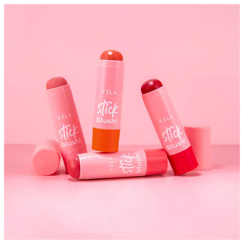 Quatro produtos de maquiagem da marca Vizzela. São blushes em formato de bastão, com embalagens plásticas nas cores rosa claro, rosa escuro e vermelho.