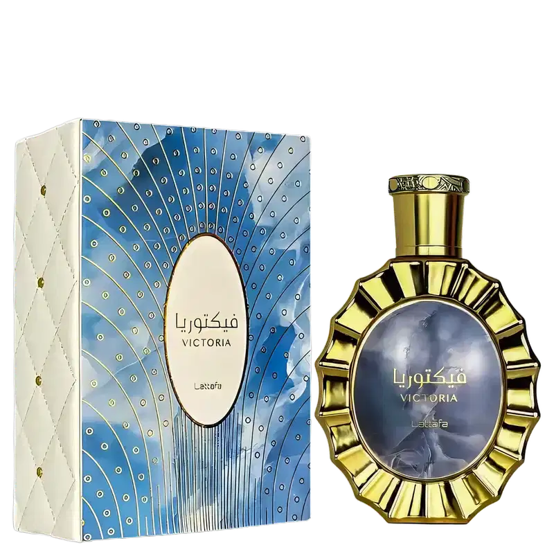 Caixa branca com padrão azul e dourado contendo item de perfumaria dourado com detalhes em azul. Rótulo com texto "Victoria" em árabe e inglês. Embalagem decorativa com design geométrico.