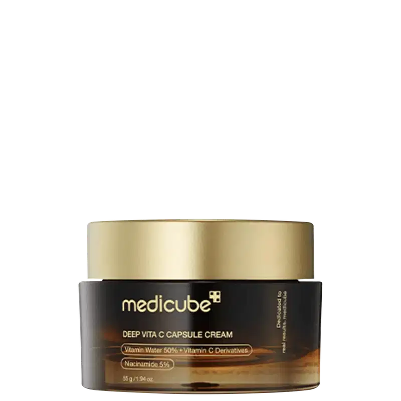 Creme Medicube Deep Vita C Capsule em frasco de vidro com tampa dourada. Embalagem preta com detalhes em ouro. Contém Vitamina C 50%, derivados de Vitamina C e Niacinamida 5%. Capacidade 55g.