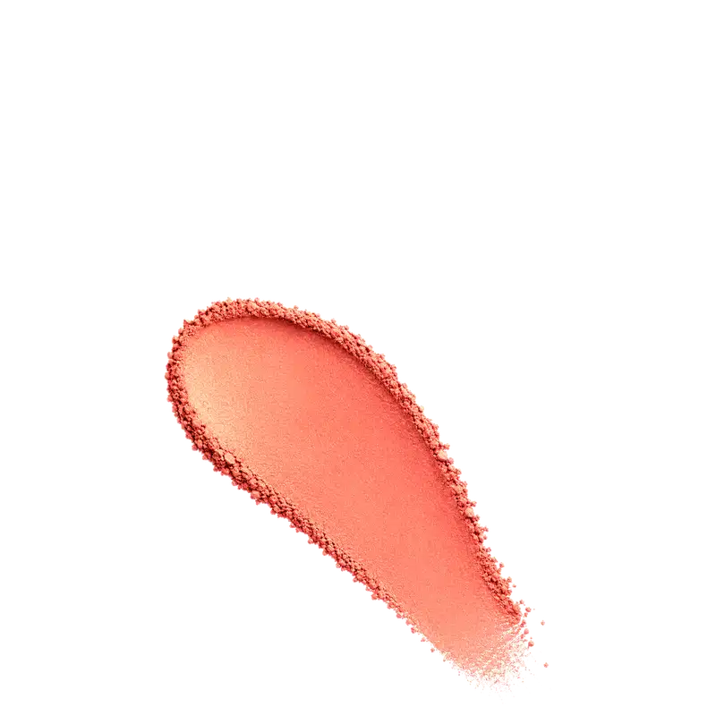 Amostra de blush em pó em tom coral, aplicado em superfície branca.