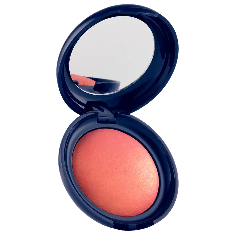 Blush em pó com embalagem redonda azul-marinho, espelho integrado na tampa e produto em tom coral com acabamento luminoso.