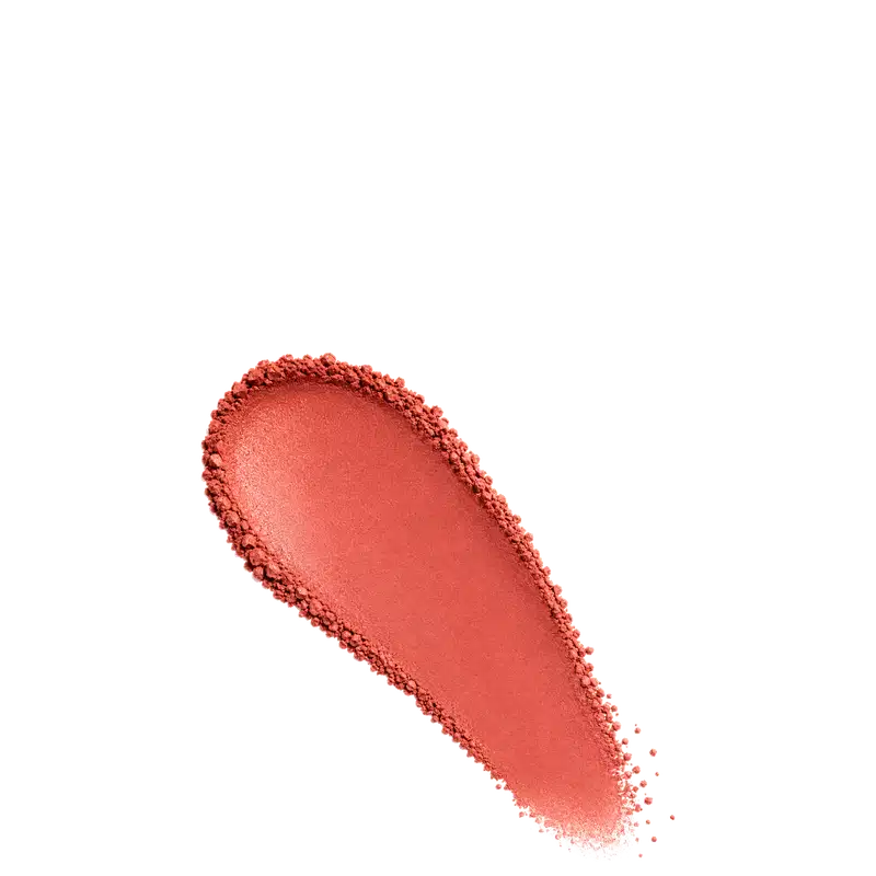 Amostra de blush em pó em tom laranja-avermelhado, aplicado em superfície branca.