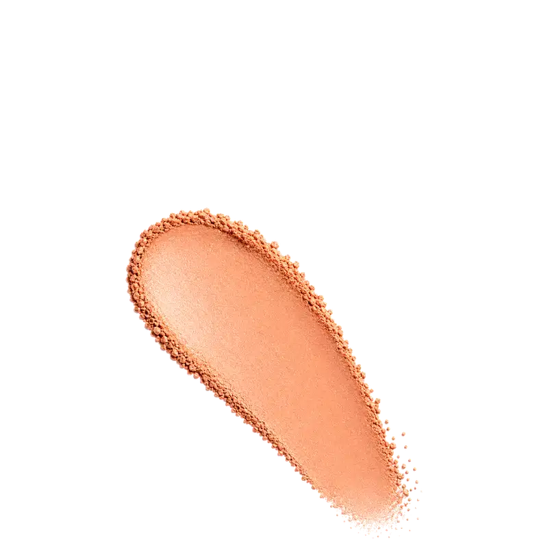 Amostra de blush em pó em tom alaranjado, aplicado em superfície branca.