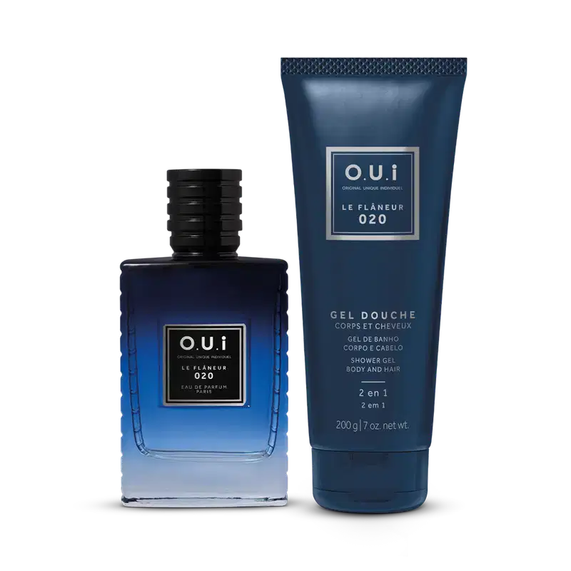 Frascos do perfume e gel de banho O.U.i Le Flâneur 020. Perfume à esquerda, em frasco de vidro azul escuro com detalhes pretos na tampa. O gel de banho, à direita, é embalado em um tubo plástico azul marinho com escrita em prata onde se lê gel douche.