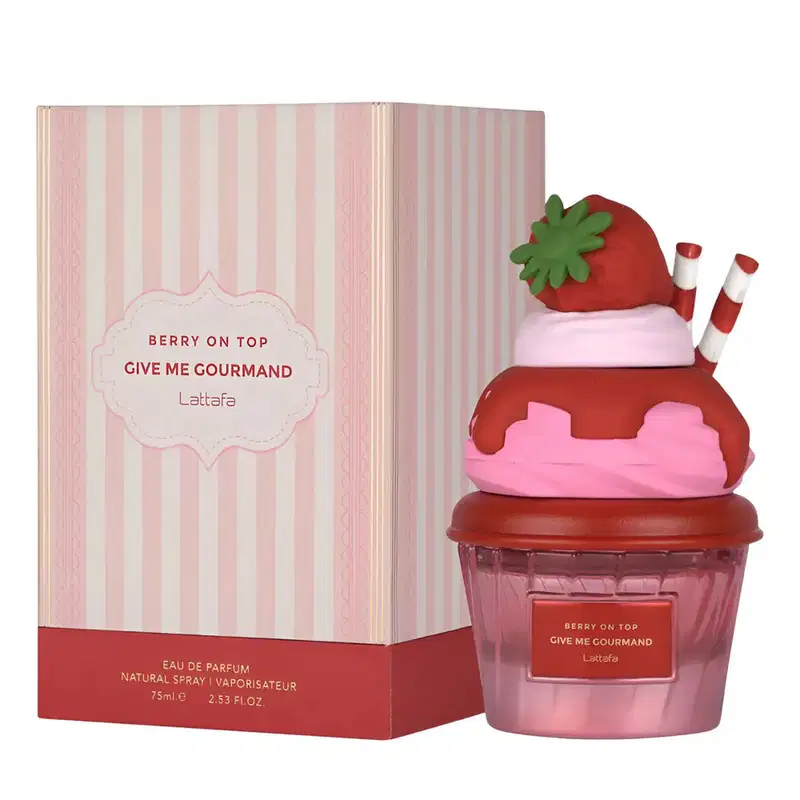 Frasco de perfume em formato de cupcake vermelho e rosa, com tampa em formato de morango verde. Rótulo indica o nome "Berry on Top Give Me Gourmand" da marca Lattafa.