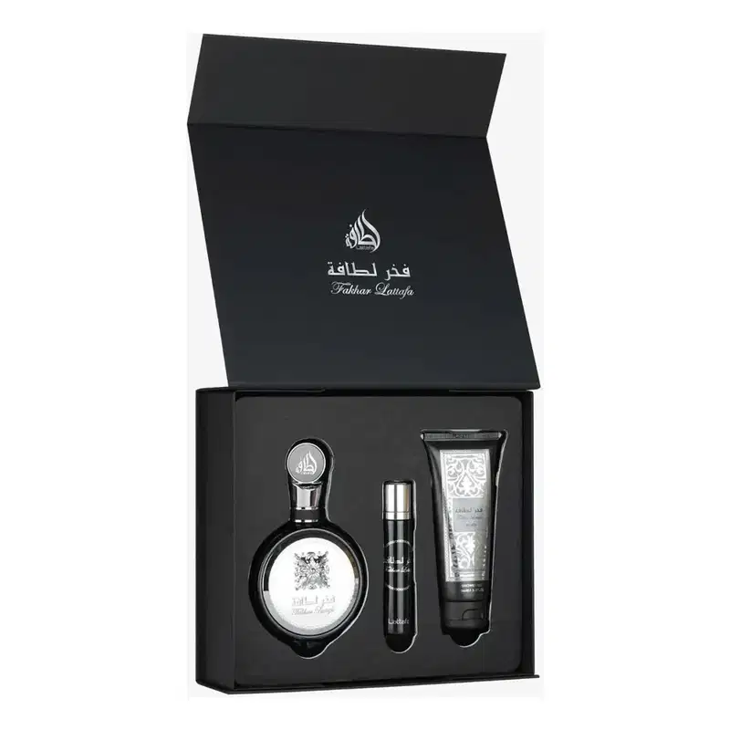Conjunto de produtos de beleza da marca Lattafa Perfumes, composto por um frasco de perfume, um travel size e um gel de banho em embalagem preta com detalhes em prata e texto em árabe.