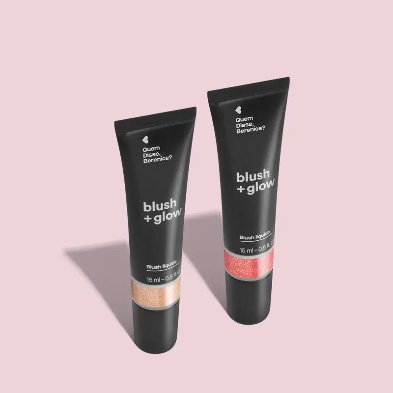 Imagem de duas bisnagas de blush líquido Blush +Glow:, sendo o Rosalix na cor rosa e o Perolali na cor prata. As embalagens são pretas com parte transparente, mostrando a tonalidade do produto e rótulo com letras brancas. O fundo é cinza com sombreado.